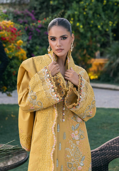 Woman wearing a yellow embroidered traditional outfit with a floral background from elaf LUXURY WINTER '25.