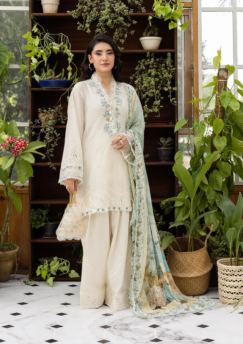 Woman in a traditional outfit standing in a room with plants