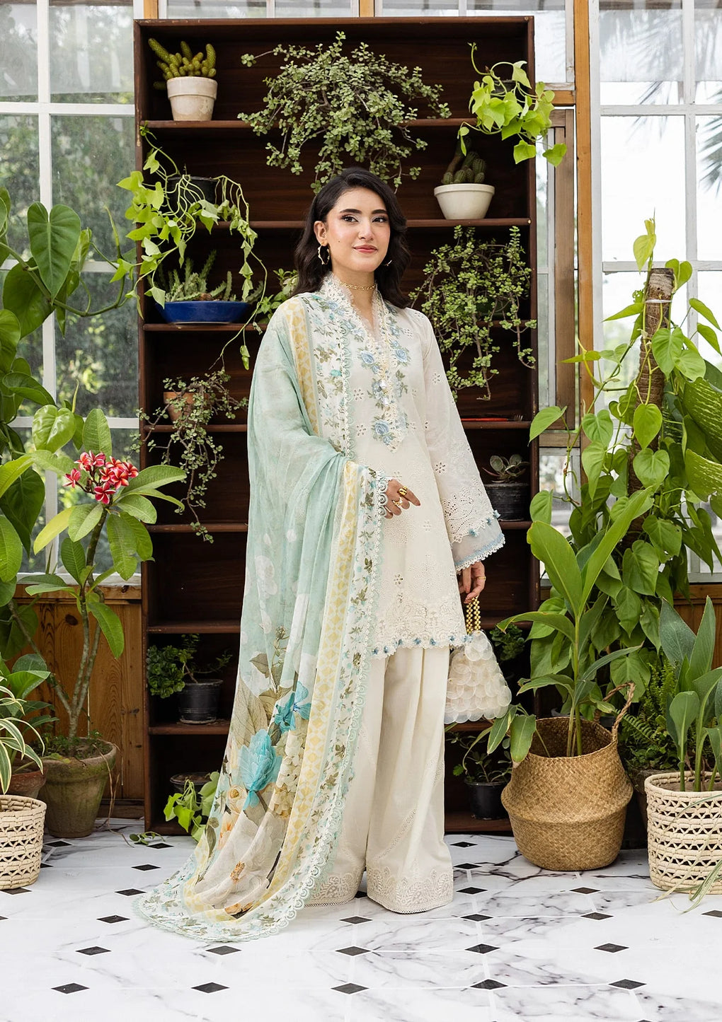 Woman in a floral outfit standing in a room with plants