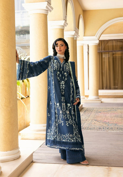Woman in a blue embroidered traditional outfit standing in an architectural setting with ELAF LUXURY WINTER