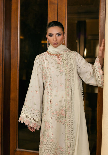 Woman wearing a light-colored embroidered traditional outfit standing indoors from elaf LUXURY WINTER '25
